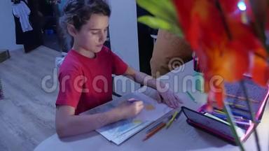 小女孩在桌子上画画。 女学生少年用铅笔在室内画画